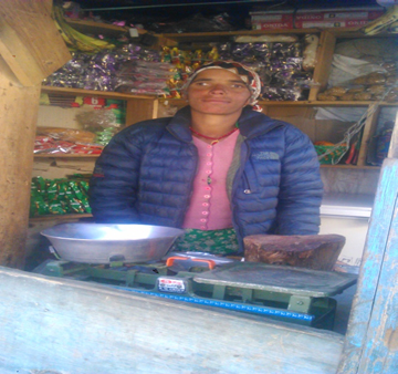 Biniti Jaisi member of the the Self-Reliant group of the Simikot branch, Humla of Nirdhan Utthan Bank Ltd(NUBL) in front of her grocery cum fresh house. She had borrowed NPR 60,000.00 from the branch office simikot
